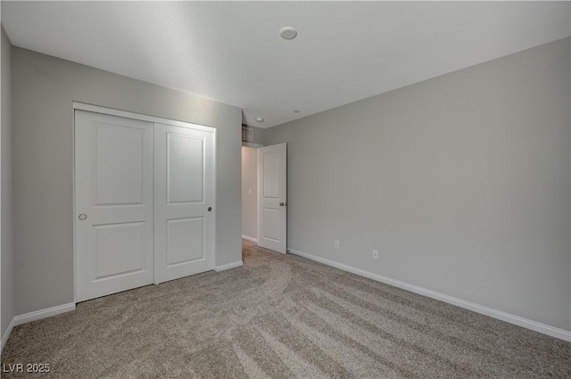 unfurnished bedroom with light carpet and a closet