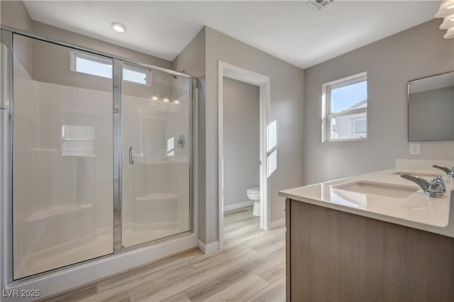 bathroom with vanity, wood-type flooring, walk in shower, and toilet