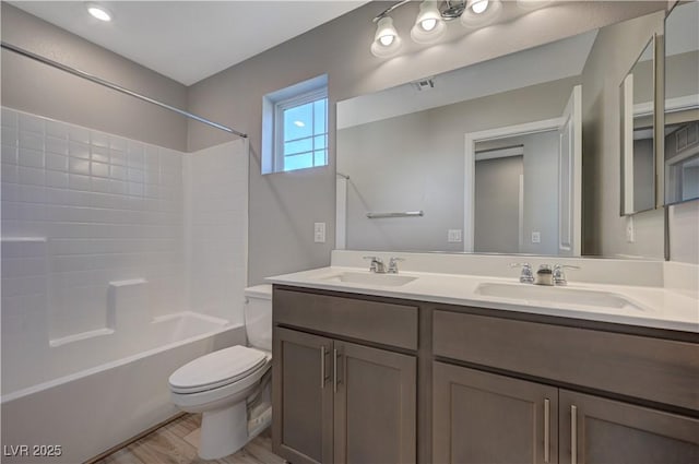 full bathroom featuring vanity, wood-type flooring,  shower combination, and toilet