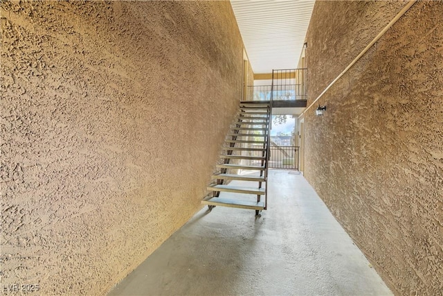 stairway featuring concrete flooring and a high ceiling