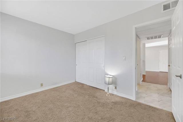 unfurnished bedroom with a closet and light colored carpet