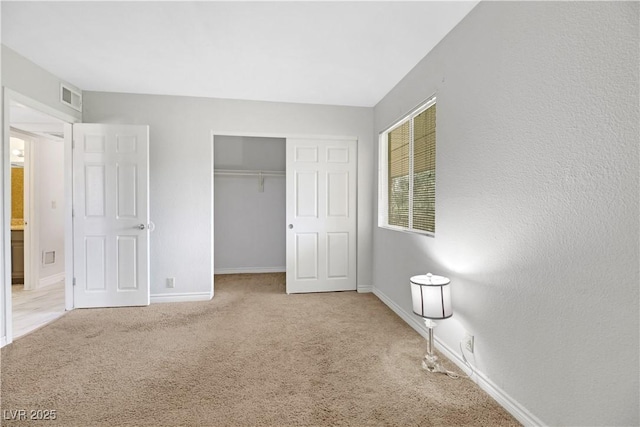 unfurnished bedroom with light colored carpet and a closet