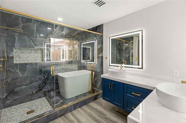 bathroom with hardwood / wood-style floors, vanity, and independent shower and bath