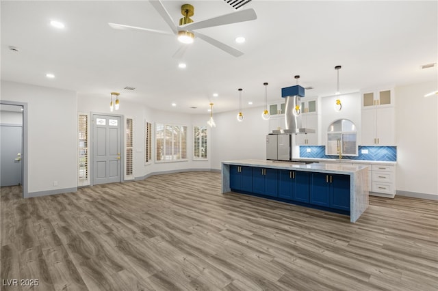 kitchen with ceiling fan, light hardwood / wood-style floors, pendant lighting, decorative backsplash, and white cabinets