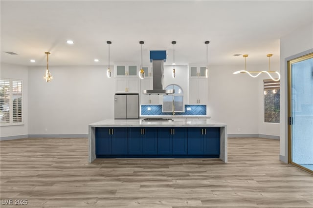 kitchen with exhaust hood, hanging light fixtures, light wood-type flooring, white cabinetry, and stainless steel appliances