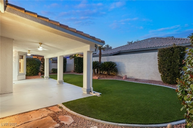 view of yard featuring ceiling fan and a patio