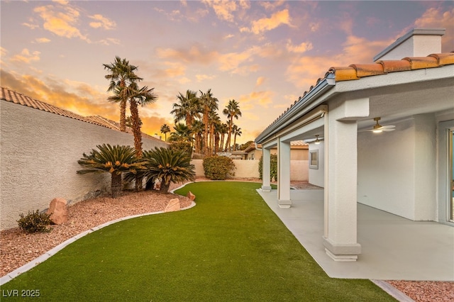 yard at dusk featuring a patio