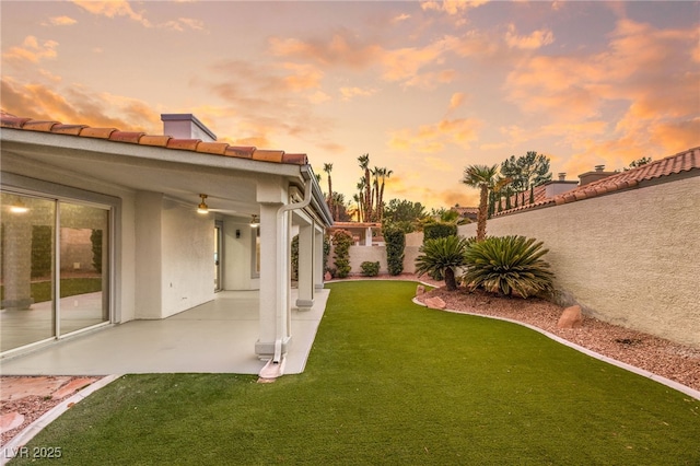 yard at dusk featuring a patio