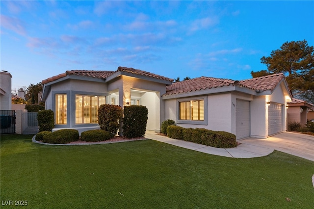 mediterranean / spanish house with a yard and a garage