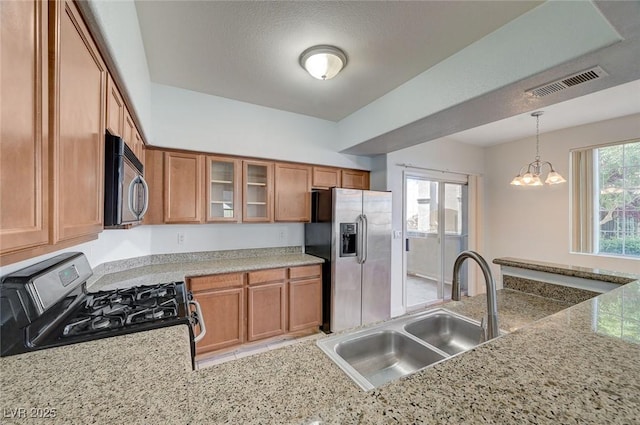 1701 King James St Unit 101, Las Vegas, NV 89144 - kitchen with appliances with stainless steel finishes, a sink, brown cabinetry, glass insert cabinets, and decorative light fixtures