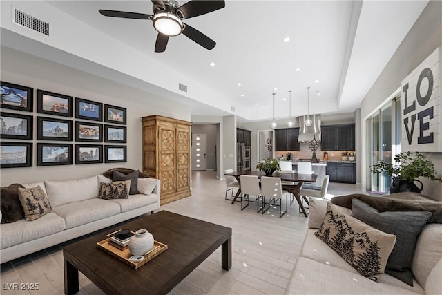 living room with ceiling fan and light wood-type flooring