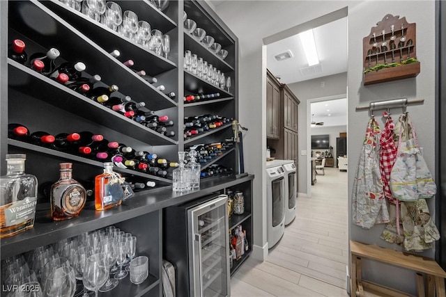 wine room with wine cooler and washer and clothes dryer