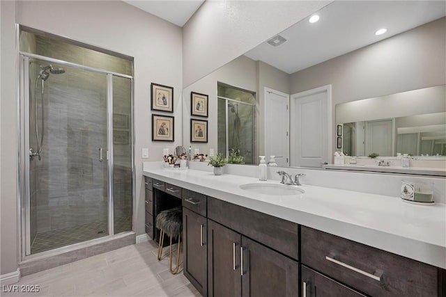 bathroom featuring tile patterned flooring, vanity, and a shower with shower door