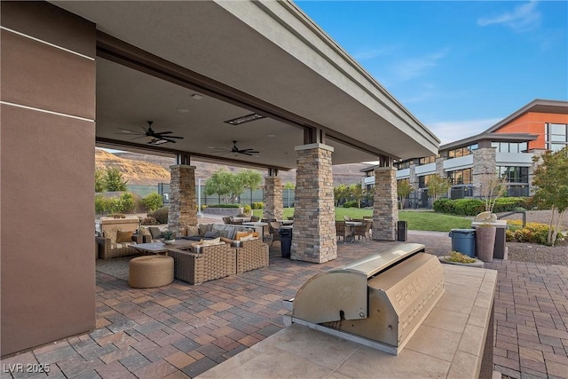 view of patio / terrace with ceiling fan, a mountain view, exterior kitchen, and an outdoor living space