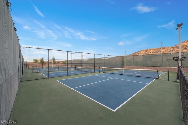 view of sport court with basketball hoop and a mountain view