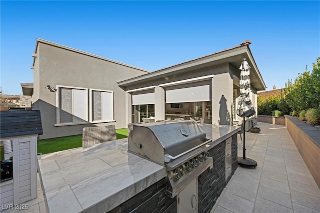 view of patio with area for grilling and an outdoor kitchen