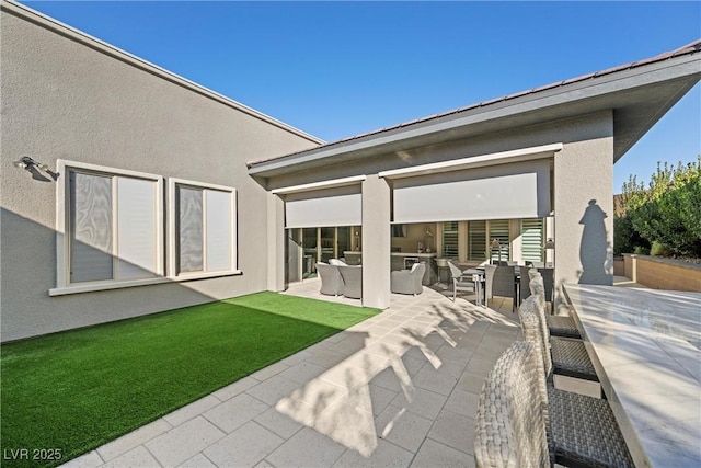 rear view of property with outdoor lounge area and a patio area