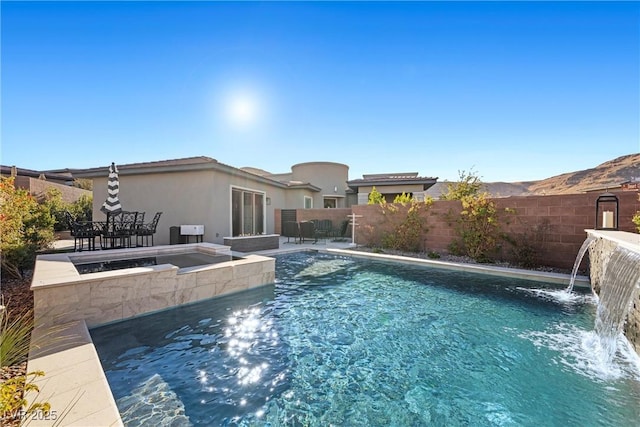 view of pool featuring an in ground hot tub and pool water feature