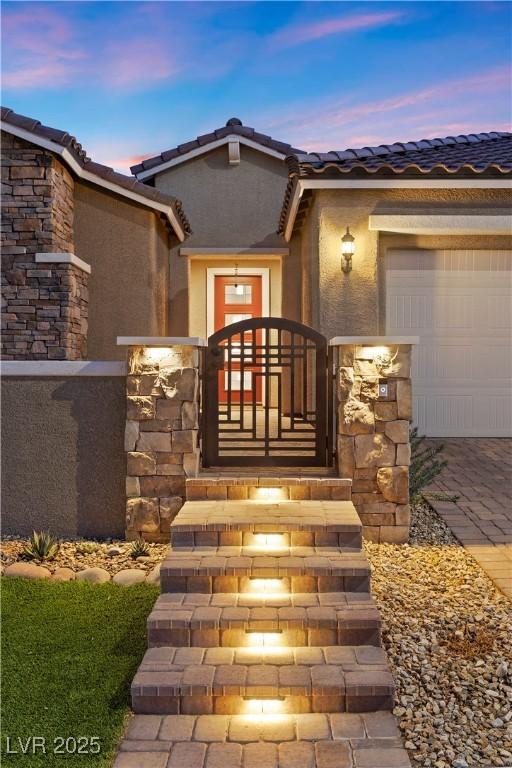 exterior entry at dusk with a garage