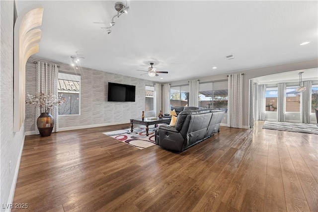 living room featuring rail lighting, dark hardwood / wood-style floors, and ceiling fan