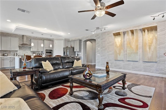 living room featuring ceiling fan and wood-type flooring