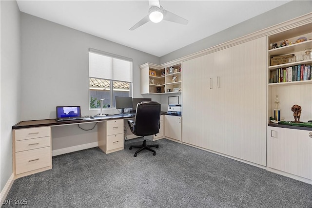 carpeted office space featuring ceiling fan and built in desk