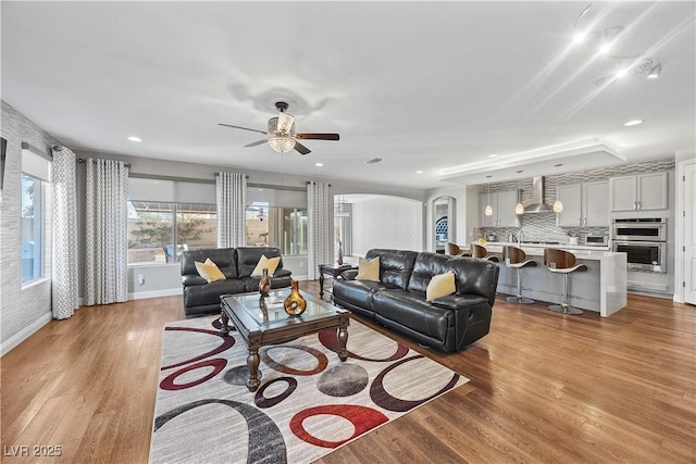 living room featuring ceiling fan and light hardwood / wood-style floors