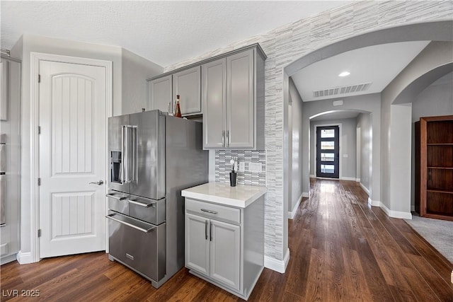 kitchen featuring high end refrigerator, dark hardwood / wood-style flooring, gray cabinets, and tasteful backsplash