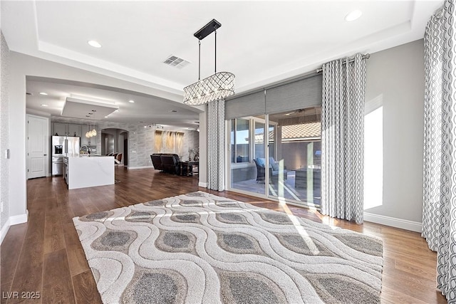 living room with a tray ceiling and dark hardwood / wood-style flooring