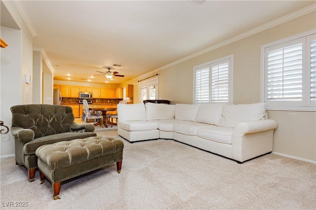 carpeted living room with ceiling fan and ornamental molding