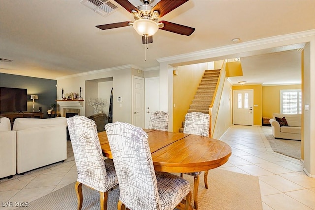 dining space with crown molding, light tile patterned floors, and ceiling fan