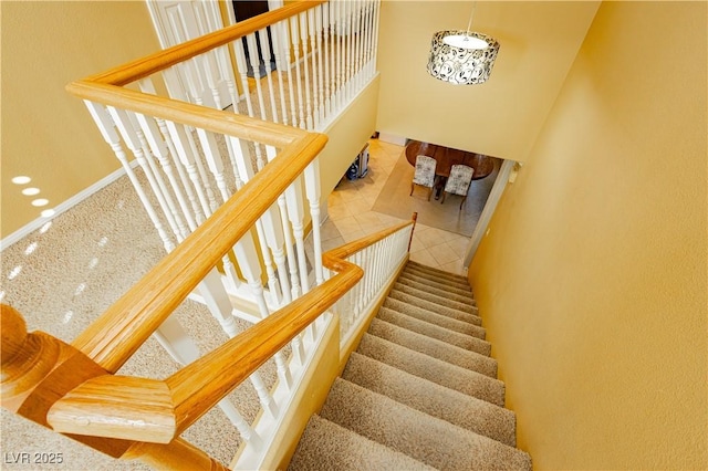 stairway with a high ceiling and tile patterned floors