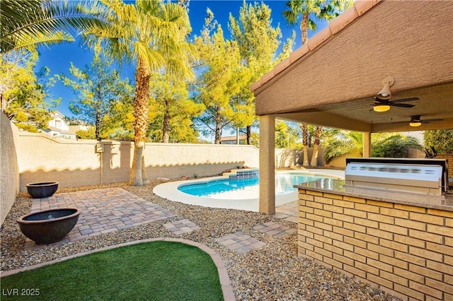 view of swimming pool featuring grilling area, ceiling fan, a patio, and an outdoor kitchen