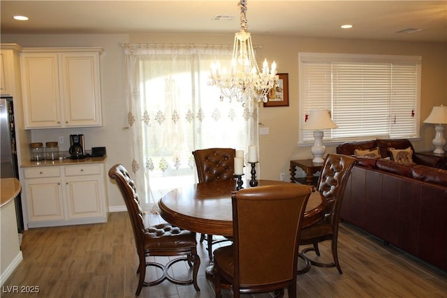 dining room featuring dark hardwood / wood-style flooring and an inviting chandelier