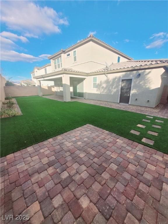 rear view of house with a yard and a patio