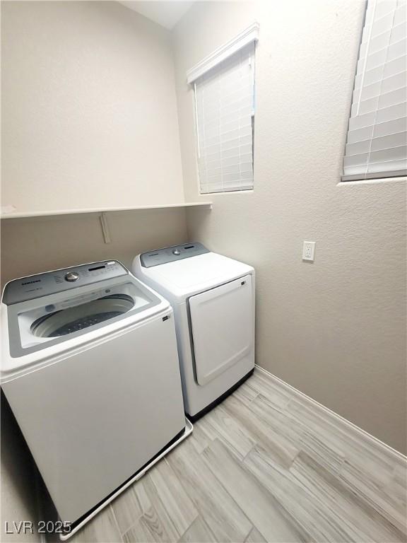 washroom featuring separate washer and dryer and light hardwood / wood-style flooring