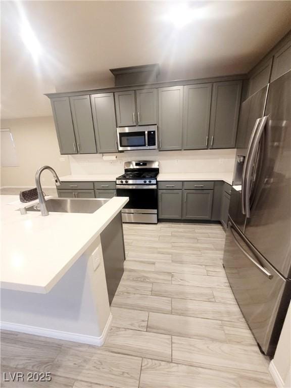 kitchen with gray cabinets, sink, and appliances with stainless steel finishes