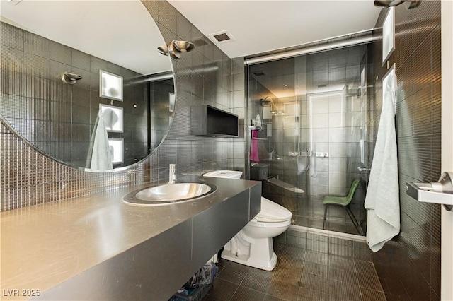 bathroom with vanity, tile patterned flooring, toilet, tile walls, and an enclosed shower