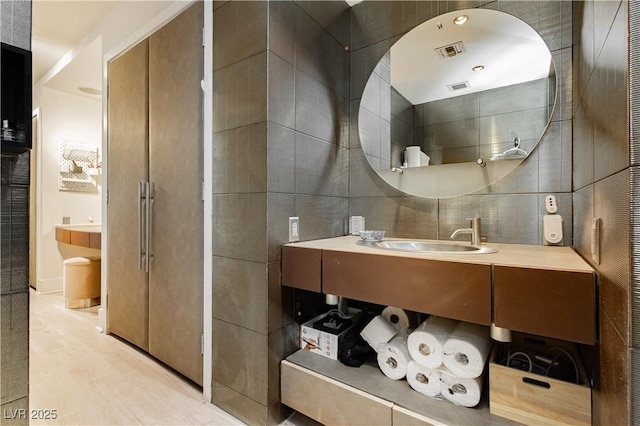 bathroom with vanity and tile walls