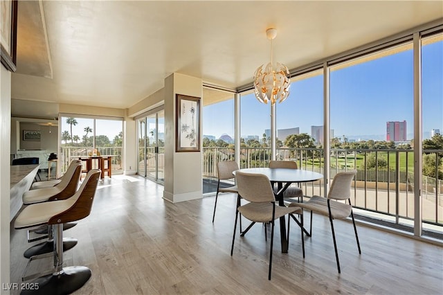 sunroom with a fireplace, a wealth of natural light, and a notable chandelier