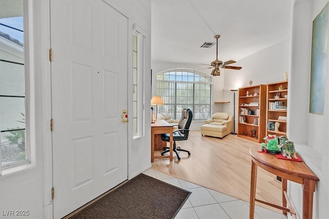 foyer featuring ceiling fan, light tile patterned flooring, and a healthy amount of sunlight