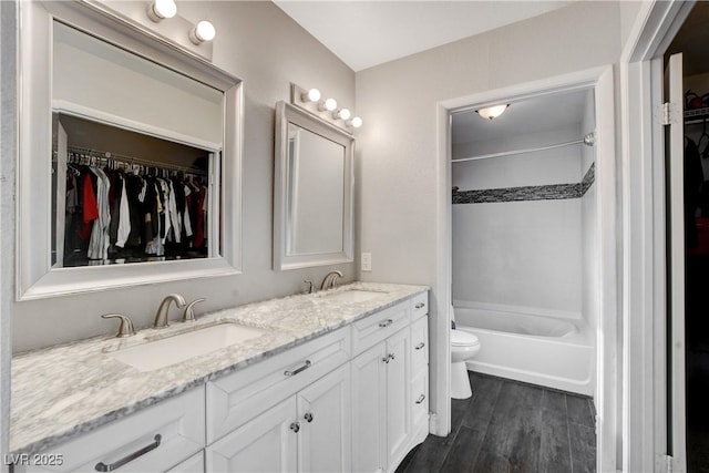 3320 Haven Beach Way, Las Vegas, NV 89117 - bathroom with toilet, double vanity, bathtub / shower combination, wood finished floors, and a walk in closet