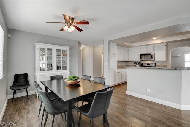 3320 Haven Beach Way, Las Vegas, NV 89117 - dining space with arched walkways, ceiling fan, baseboards, wood finished floors, and a tray ceiling