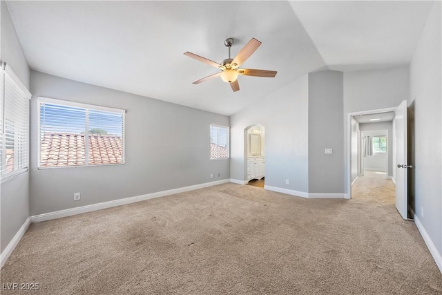 3320 Haven Beach Way, Las Vegas, NV 89117 - unfurnished bedroom with light colored carpet, multiple windows, lofted ceiling, and arched walkways