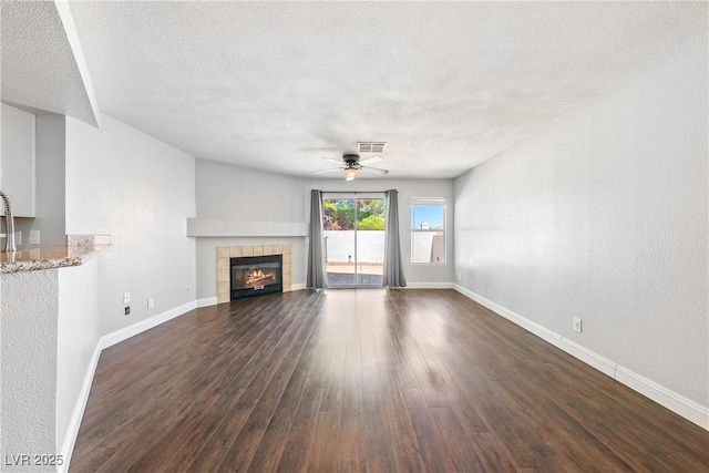 3320 Haven Beach Way, Las Vegas, NV 89117 - unfurnished living room with dark wood-style floors, a textured ceiling, ceiling fan, and a tiled fireplace