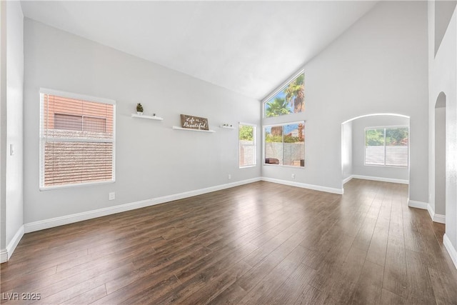 3320 Haven Beach Way, Las Vegas, NV 89117 - unfurnished living room featuring high vaulted ceiling, arched walkways, and dark wood-style floors