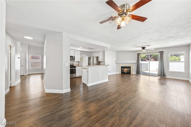 3320 Haven Beach Way, Las Vegas, NV 89117 - unfurnished living room with a ceiling fan, dark wood-type flooring, and a tile fireplace