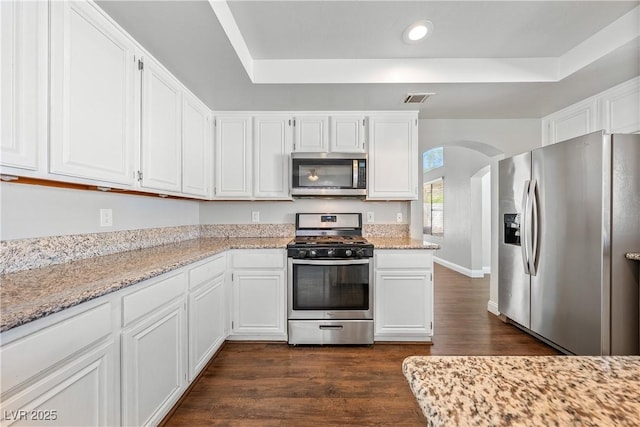 3320 Haven Beach Way, Las Vegas, NV 89117 - kitchen featuring appliances with stainless steel finishes, dark wood-style floors, recessed lighting, white cabinets, and arched walkways