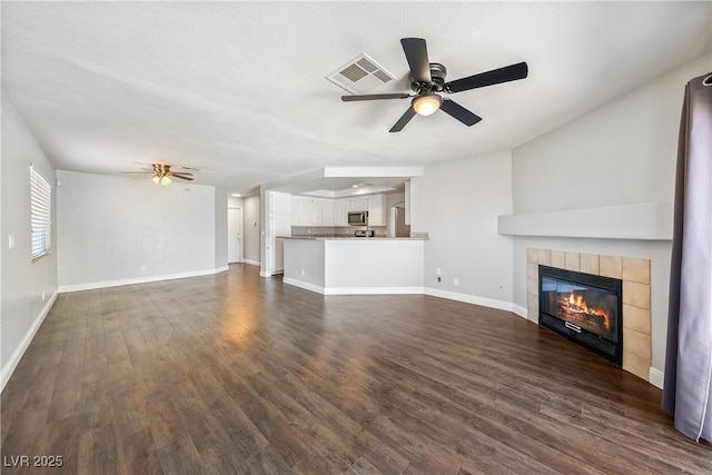 3320 Haven Beach Way, Las Vegas, NV 89117 - unfurnished living room with a ceiling fan, a fireplace, and dark wood-style floors
