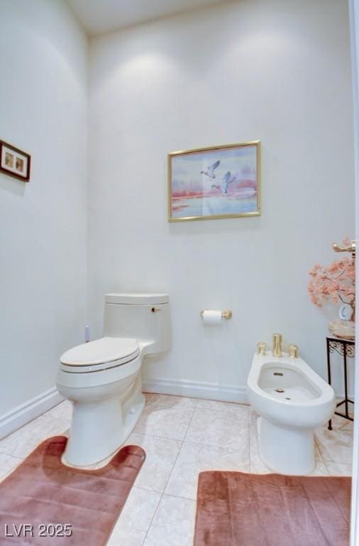 bathroom with tile patterned floors, a bidet, and toilet